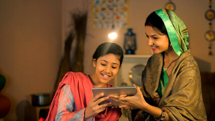 An Indian housewife and her young daughter making a video call on a tablet - digital device  modern...