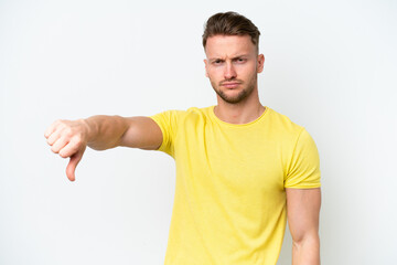 Young blonde caucasian man isolated on white background showing thumb down with negative expression