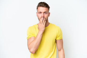 Young blonde caucasian man isolated on white background covering mouth with hand