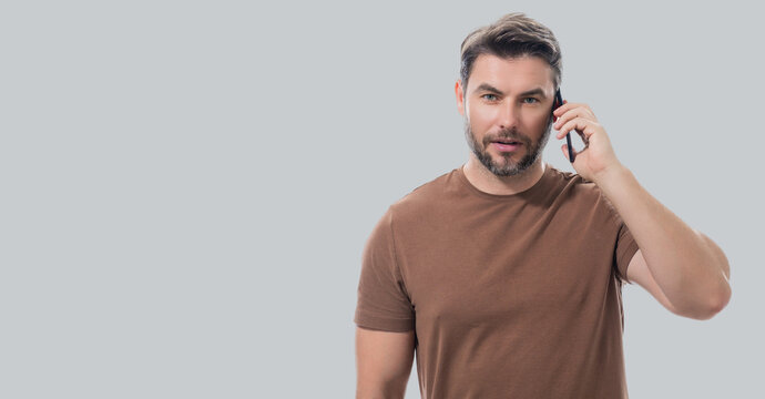 Handsome man using mobile phone isolated on studio background. Portrait of confidence middle aged millennial man using cellphone. Guy with smartphone isolated studio background. Banner, copy space.