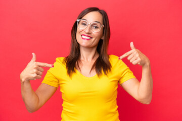 Middle-aged caucasian woman isolated on red background proud and self-satisfied
