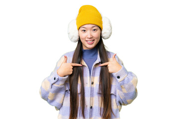 Young Asian woman wearing winter muffs over isolated chroma key background with surprise facial expression