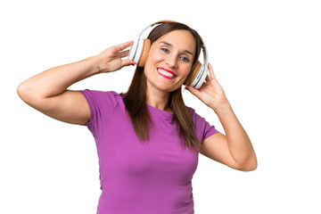 Fototapeta premium Middle-aged caucasian woman over isolated background listening music