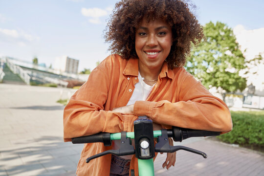 Front view of black woman riding on electric scooter