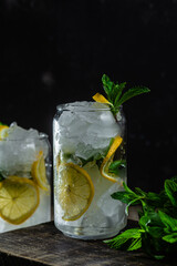 Cold lemonade with mint and lemon and ice on a dark background