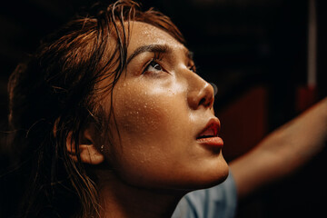 Face of female athlete with sweat while working out at gym