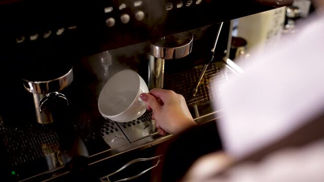 Coffee shop lifestyle small business owner concept, woman barista hand provide milk to steam milk foam for hot cappuccino cup, staff or business trainee learning techniques to open coffee shop
