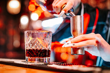 woman hand bartender making negroni cocktail in bar