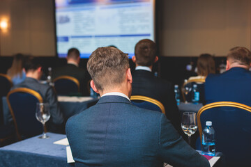 Audience at the modern conference hall listens to lecturer, people on a congress together listen to...