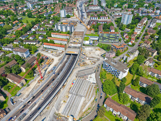Fototapeta premium Aerial view of City of Zürich North with highway enclosure construction site on a sunny spring day. Photo taken May 27th, 2023, Zurich, Switzerland.