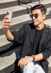 a young man is taking a selfie photo or talking on the phone, concept of using social networks, blogging