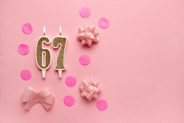 Number 67 on pastel pink background with festive decor. Happy birthday candles. The concept of celebrating a birthday, anniversary, important date, holiday. Copy space. banner