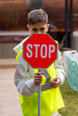 A boy is holding a stop sign. Red stop sign, symbol
of detention. Concept of fight against child labor exploitation, prohibition concept, stop gender violence, child abuse