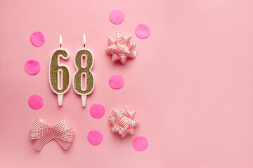 Number 68 on pastel pink background with festive decor. Happy birthday candles. The concept of celebrating a birthday, anniversary, important date, holiday. Copy space. banner