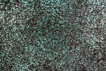 Green background from decorative plaster with abstract spots. Unusual green wall texture with beautiful patterns, creative surface background. Front covering for facing of buildings.