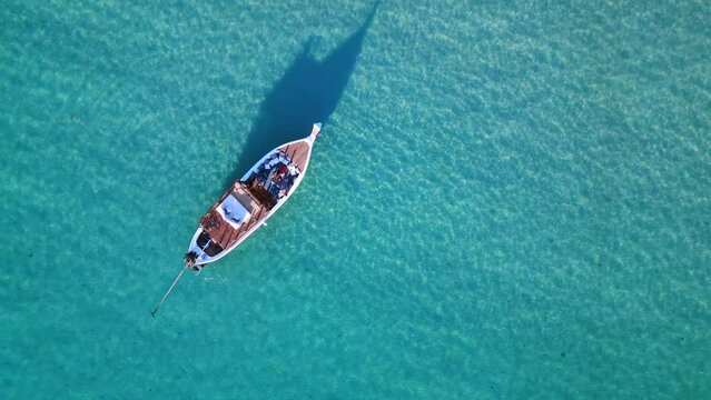 Luxurious boad in crystal clear water. Stunning aerial top view flight drone
