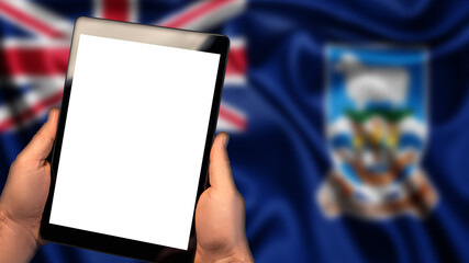 Man hold tablet phone pc gadget with white blank screen, copy space for text, image or message. Flag of Falkland Islands country on background. Technology, information, business
