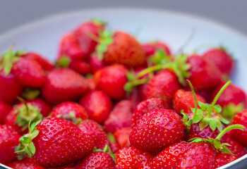 Organic strawberries on a plate close up. Red strawberry selective focus with copy space.