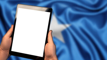 Man hold tablet phone pc gadget with white blank screen, copy space for text, image or message. Flag of Somalia country on background. Technology, information, business 