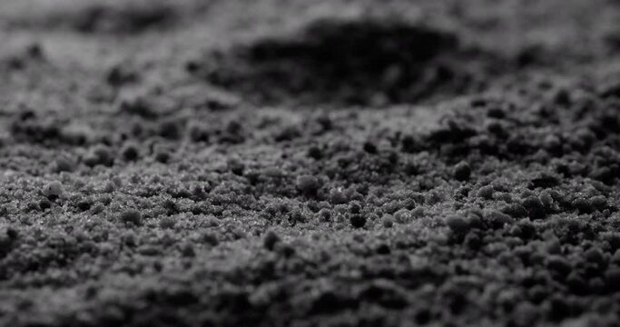Black sand grunge background. Close-up.