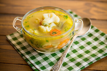 cooked chicken soup with cauliflower and vegetables in a bowl