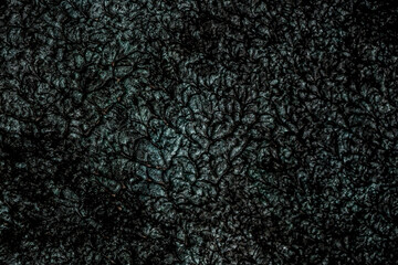 Dark background of decorative plaster with abstract spots. Unusual black or gray wall texture with beautiful patterns, creative surface background. Finishing coating for building cladding.