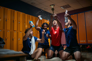 Group of men players holding golden medal and splashing water, feeling joyful about winning first place.