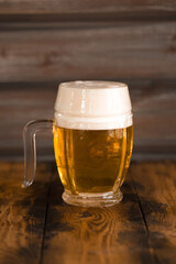 A mug of foamy beer close-up on a wooden table in a pub. Glasses of light and dark beer with foam.