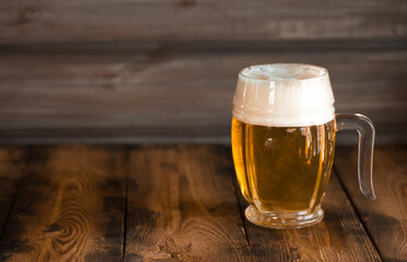 A mug of foamy beer close-up on a wooden table in a pub. Glasses of light and dark beer with foam.
