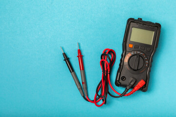 Electrician equipment on blue background with copy space.Top view.Electrician tool set.Multimeter, tester,screwdrivers,cutters,duct tape,lamps,tape measure and wires.Flet lay. © Avocado_studio