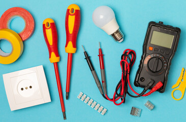 Electrician equipment on blue background with copy space.Top view.Electrician tool set.Multimeter,...