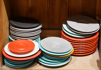 Colored ceramic plates and saucers in a pottery workshop. Folk crafts. Ceramic dishes on a shelf in a pottery workshop, in a shop.