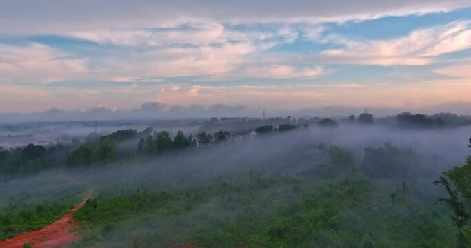 Spring morning mist in forest mountains gently blankets landscape, creating an enchanting as sun rises