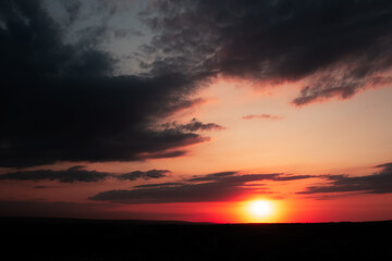 Fototapeta na wymiar Natural landscape of beautiful colourful sunset with dark clouds.