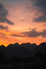 Mountain as the sun sets. Mountain peak green nature scenery. Beautiful sunset over the mountain range at vang vieng.