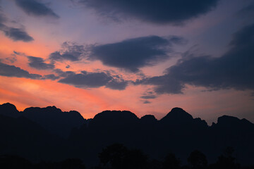 Mountain as the sun sets. Mountain peak green nature scenery. Beautiful sunset over the mountain range at vang vieng.