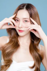 Fotobehang Young Asian beauty woman curly long hair with korean makeup style on face and perfect clean skin on isolated blue background. Facial treatment, Cosmetology, plastic surgery. © Auttapol