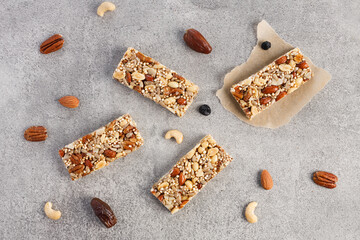 Energy sports muesli bar with nuts and dried fruits on grey background, top view. Granola bars snacks for yoga and fitness. No sugar