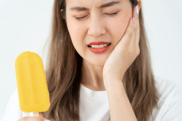 Asian woman feel sensitive teeth after eating ice cream, female suffer tooth, decay problems,...