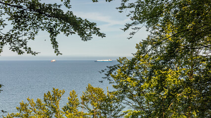 Hochufer mit Wald und Blick auf die Ostsee in Sellin - LNG Schiffe in der Bucht vor Mukran
