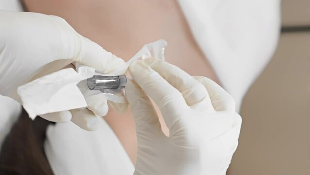 Cosmetologist takes out and puts on sterile new nozzle on dermapen for procedure fractional mesotherapy. New technology non-injection therapy drug injection into skin in beauty clinic. Vertical video