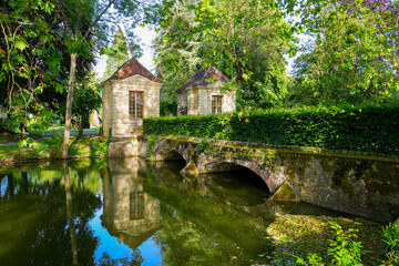 Fototapeta na wymiar Ancient bridge spanning the Grand Morin river in the Parc des Capucins (