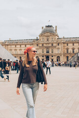 woman tourist wearing a red kerchief and sunglasses at the louvre in paris
