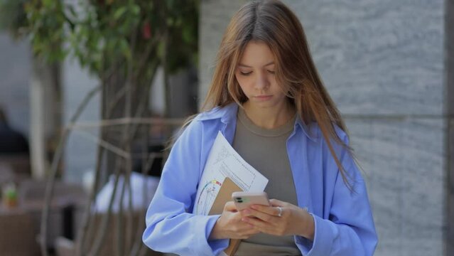 A numerologist girl with a numerological analysis and a phone in her hands. future by date of birth, find out her purpose with the help of numbers