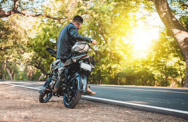Man sitting on his motorcycle at the side of the road. Biker sitting on his motorcycle at the side of the road