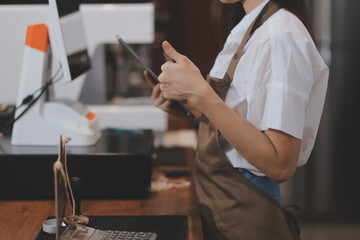 Portrait of a woman, a coffee shop business owner who is smiling beautifully and opening a coffee shop that is her own business, SME concept.