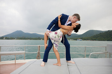 Fototapeta young couple smiling and hugging each other on luxury yacht obraz