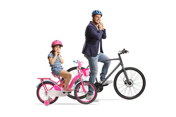 Fototapeta premium Father and daughter with bicycles putting helmets on