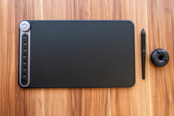 Obraz premium Electronic graphic tablet with a pen for drawing on the table.