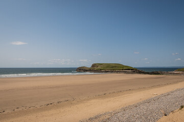 Sandy beach on Rhossili Bay, Gower peninsula, South Wales, UK. popular British coastal staycation getaway in area of outstanding natural beauty for outdoor lifestyle and rugged adventure in nature